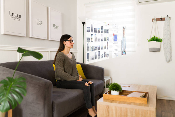 Concept van mooie jonge vrouw thuis met augmented reality bril voor haar dagelijkse activiteiten  - Foto, afbeelding