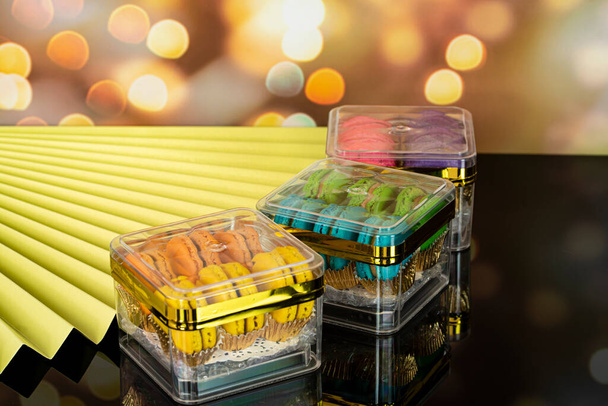 Deliziosi amaretti, un famoso dessert francese in scatola sigillata trasparente in vendita. Concentrazione selettiva. Sfondo sfocato - Foto, immagini