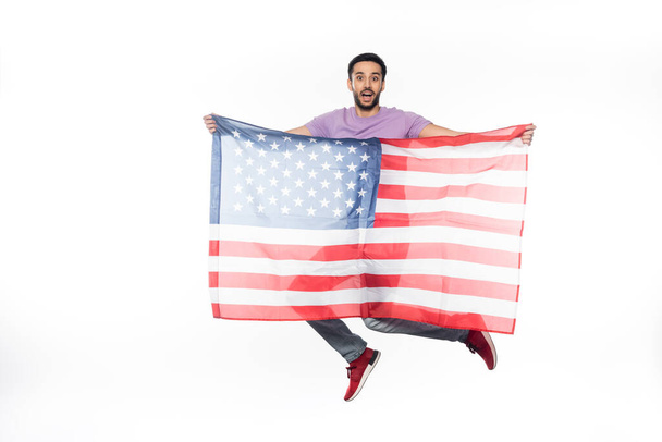 positive and patriotic man jumping with american flag isolated on white - Photo, Image