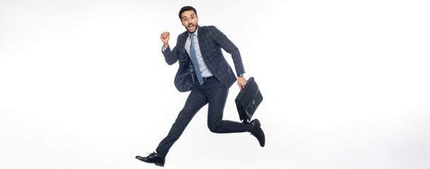 hombre de negocios positivo en traje saltando con maletín en blanco, bandera - Foto, imagen