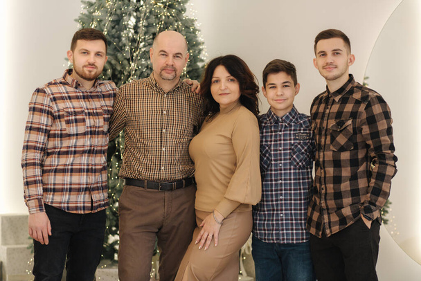 Mother and father with their three sons smile. Big family of four man and one woman. Chrismas feiry tail - Fotografie, Obrázek
