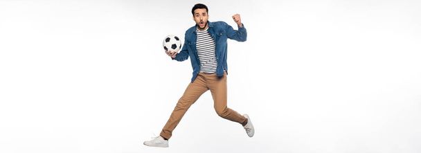 ustaraný muž levitující při držení fotbalového míče a jásání na bílém, prapor - Fotografie, Obrázek