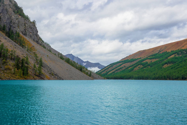 Caldera plná tyrkysové vody, pozůstatek starobylého jezera na pozadí zalesněných hor. - Fotografie, Obrázek