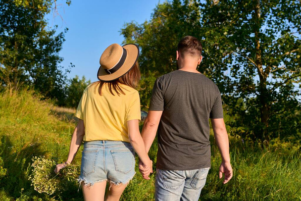 Happy romantic middle age couple, walking together holding hands, back view - Foto, Bild