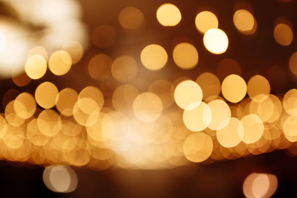 Christmas gold background. Festive abstract background with bokeh defocused lights. - Photo, Image