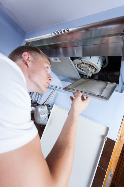 Handyman repairing kitchen extractor fan - 写真・画像