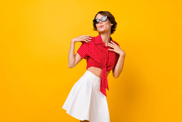 Photo of young beautiful pretty charming girl in sunglasses dancing look copyspace isolated on yellow color background - Photo, Image