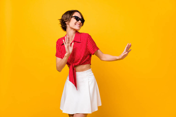 Photo of optimistic nice brunette lady look empty space wear spectacles shirt skirt isolated on yellow color background - Фото, зображення