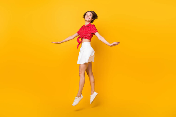 Full body profile portrait of charming carefree girl jumping high toothy smile isolated on yellow color background - Foto, Imagem