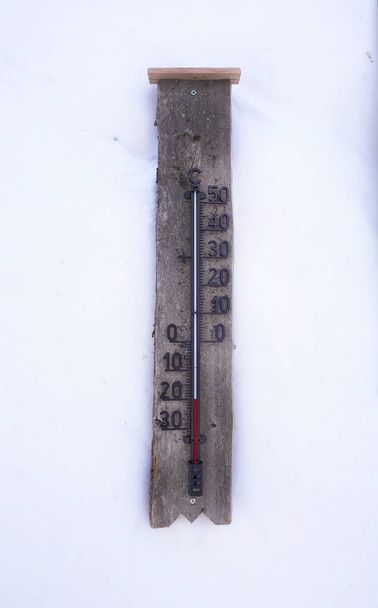 a wooden thermometer on snow wall showing minus 20 Celsius below zero arctic circle lapland - Fotoğraf, Görsel