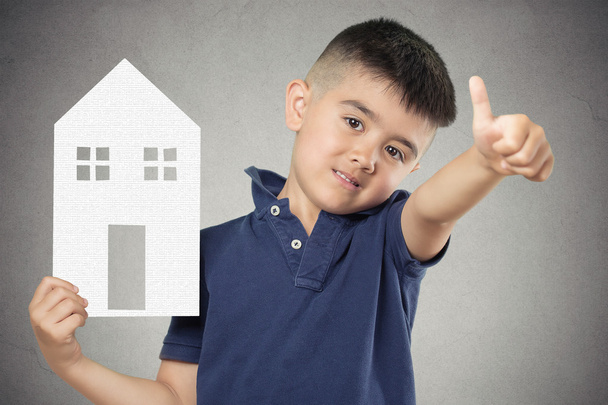 Child holding paper house showing thumbs up - 写真・画像