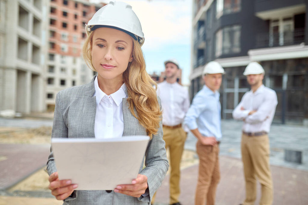Business woman studying document at construction site - Photo, Image