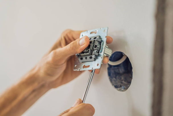 Master electrician installs a socket in the house - Zdjęcie, obraz
