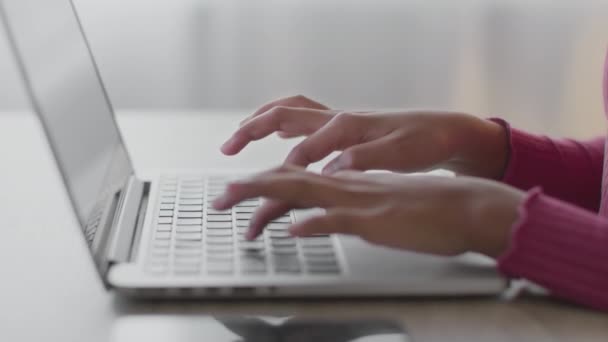Niños y tecnologías. Chica afroamericana irreconocible escribiendo en el teclado del ordenador portátil, estudiando en la escuela en línea - Imágenes, Vídeo