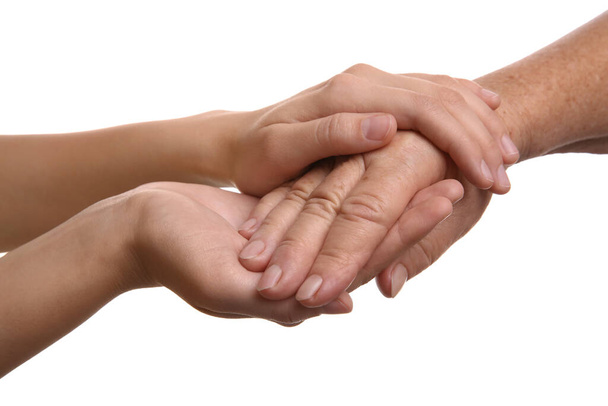 Young and elderly women holding hands together on white background, closeup - Foto, Imagem