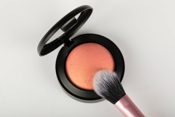 Picture of rose gold blush and makeup brush on white background - Fotó, kép