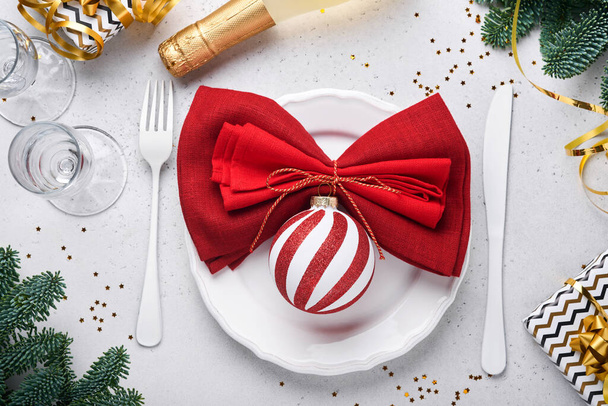 Christmas table setting white color with silverware, napkin red color, Christmas balls, champagne, glasses on white background for xmas greetings. Mock up. - Foto, Imagem