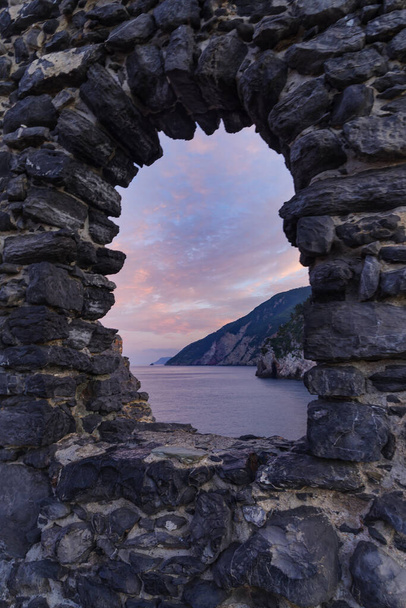 Скелясті гори на березі моря бачили через вікно кам'яної арки. Італія, Лігурія, Портов "єне - Фото, зображення