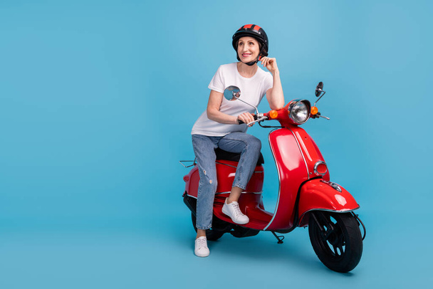 Portrait of attractive dreamy cheerful dreamy woman sitting on moped thinking isolated over bright blue color background - Fotoğraf, Görsel