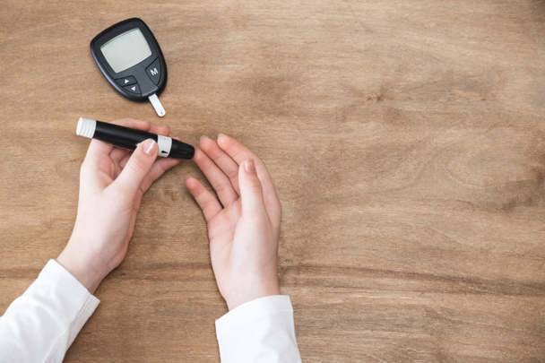 Diabetes die de bloedsuikerspiegel controleert. Kind met lancelet en glucometer - Foto, afbeelding