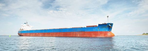 Μεγάλο μπλε πλοίο μεταφοράς χύδην φορτίου (πλοίο) που πλέει στη Βαλτική θάλασσα προς το λιμάνι της Ρίγας, Λετονία. Θέα από το γιοτ. Γενικό φορτίο. Διεθνείς επικοινωνίες, εφοδιαστική, βιομηχανία, εμπορευματικές μεταφορές - Φωτογραφία, εικόνα
