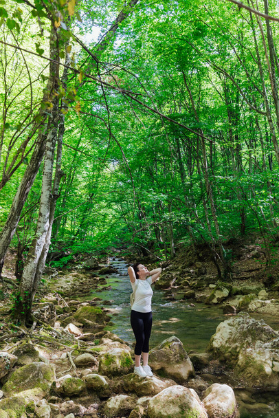 beautiful tourist woman walking through the green forest on a journey - Fotoğraf, Görsel