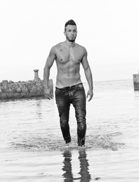 Handsome muscular man on the beach. - Foto, afbeelding