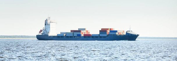 Gran buque portacontenedores de carga que zarpa de Europoort (Rotterdam, Países Bajos) en un día despejado, de cerca. Transporte de mercancías, comunicaciones globales, logística, daños ambientales tema - Foto, imagen