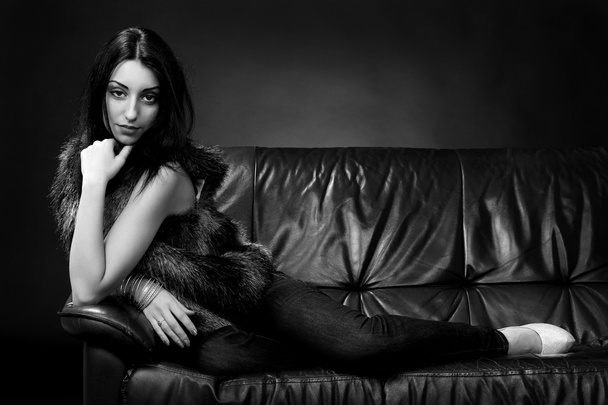 Brunette in fur on the couch - Foto, afbeelding