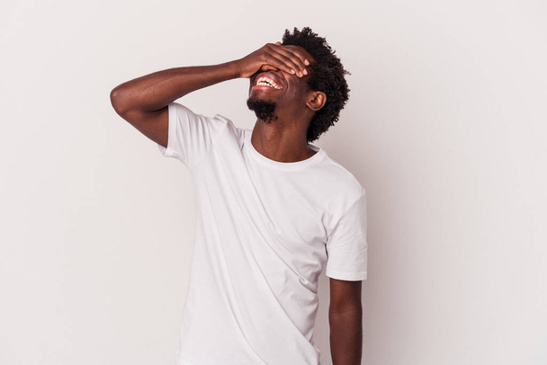 Jovem afro-americano isolado em fundo branco ri alegremente mantendo as mãos na cabeça. Conceito de felicidade. - Foto, Imagem