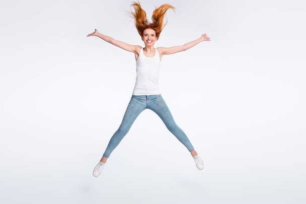 Full size photo of funny positive red hairdo lady jump wear white top jeans isolated on bright color background - Foto, imagen