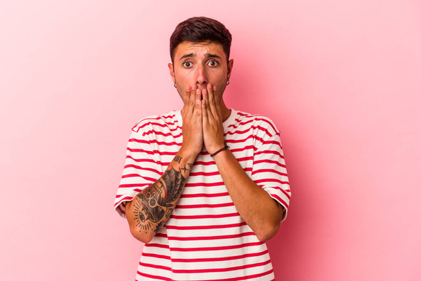 Young caucasian man with tattoos isolated on yellow background  shocked covering mouth with hands. - Photo, Image