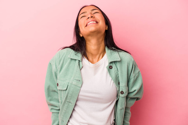 Young latin woman isolated on pink background  laughs and closes eyes, feels relaxed and happy. - Photo, Image