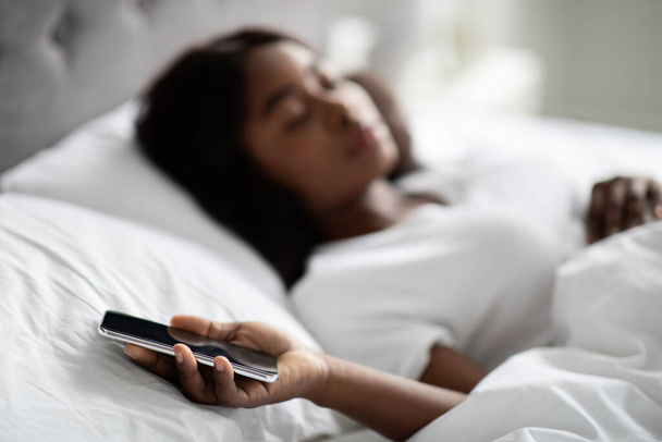 Africaine américaine dame dormir avec smartphone dans sa main - Photo, image
