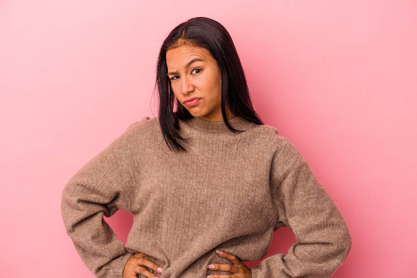 Young latin woman isolated on pink background  confused, feels doubtful and unsure. - Foto, Imagem