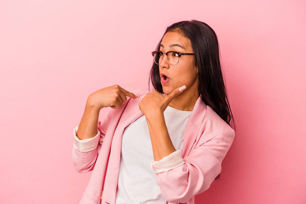 Young latin woman isolated on pink background  surprised pointing with finger, smiling broadly. - Foto, immagini