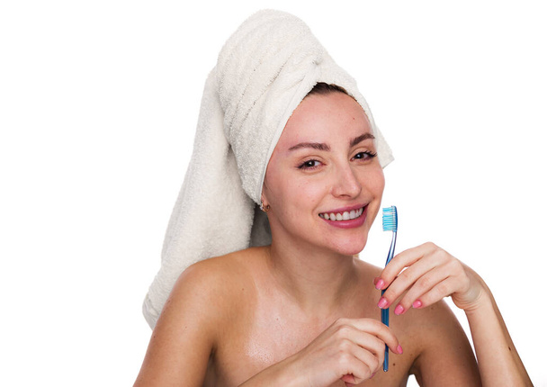 Cute and excited beautiful woman holds toothbrush and wearing towel on her head. Female has cleen skin shows white teeth, poses with naked body isolated over white background - Photo, Image