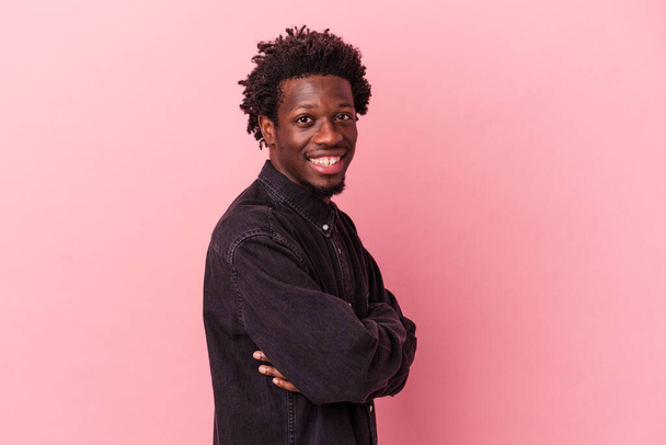 Young african american man isolated on pink background who feels confident, crossing arms with determination. - Foto, immagini