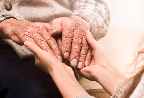 young female hands holding the hands of an elderly man - Photo, Image