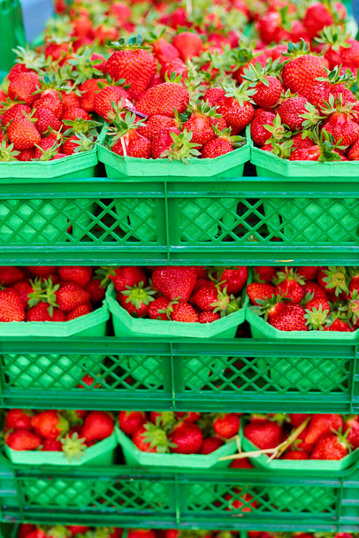 Crates of fresh ripe strawberries on grocery store shelves. - Foto, immagini