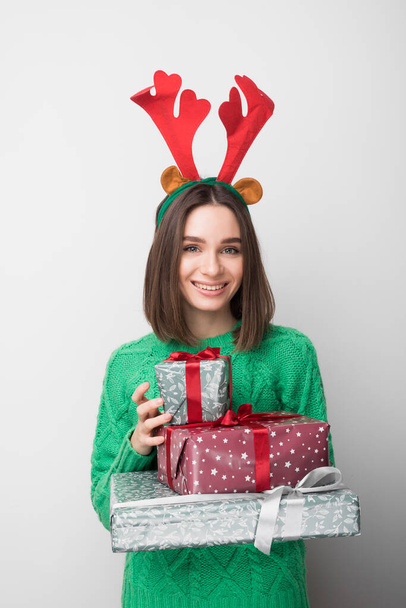 Isolated young smiling girl holds red and green gifts - Photo, Image