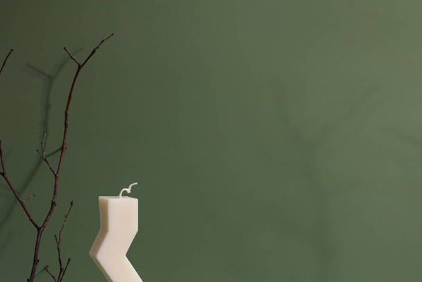 Zigzag shape soy candle on green background .Modern homemade candle, trendy hobby  - Valokuva, kuva