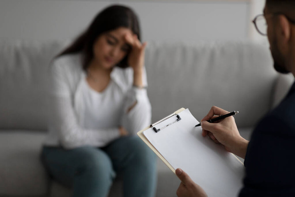 Депресивний південно-східна жінка консультує психолога в медичному кабінеті, зосереджується на написанні психіатрів в буфері
 - Фото, зображення