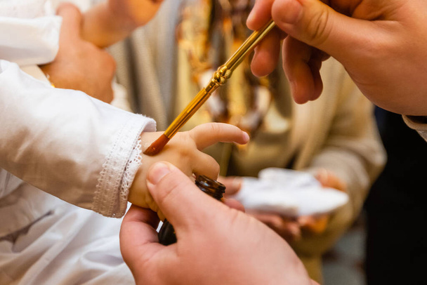 Orthodox christening of a baby, holding gold cross - Foto, afbeelding