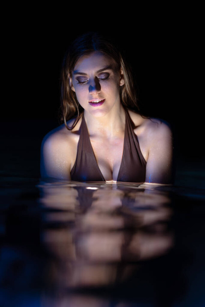 An attractive Caucasian woman with a sexy bikini on a swimming pool - Фото, зображення