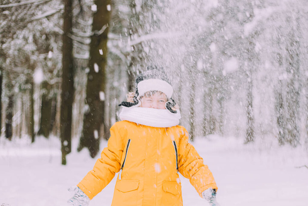 The boy throws snow in winter lifestyle . Winter walks. An article about children's winter leisure. Entertainments - Fotoğraf, Görsel