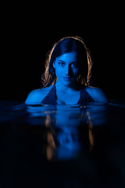 An attractive Caucasian woman with a sexy bikini on a swimming pool - Fotó, kép