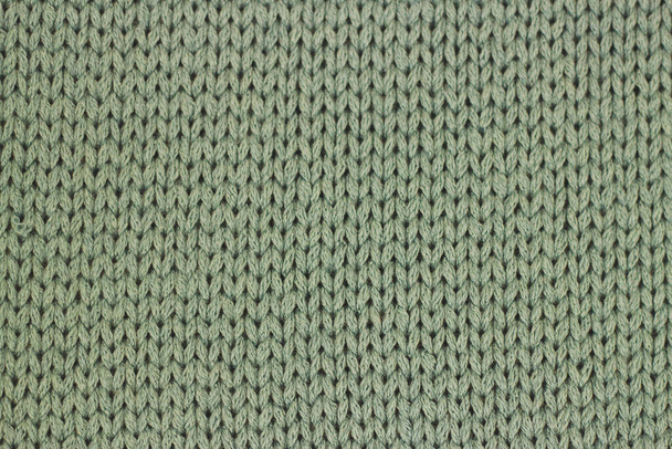 The texture of knitted green fabric background - Foto, afbeelding