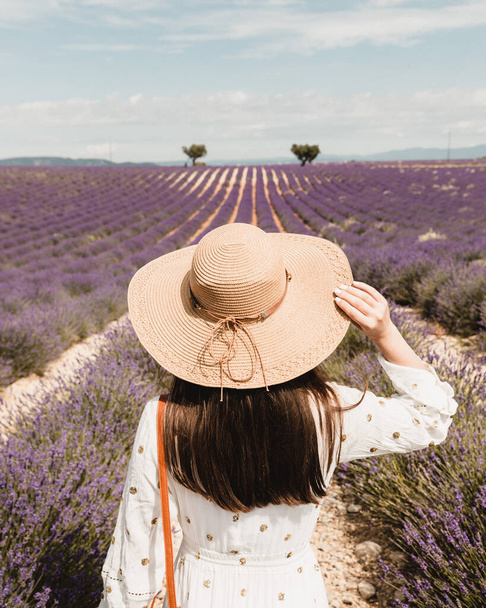 A vertical shot of the woman looking at the lavender field. - Valokuva, kuva