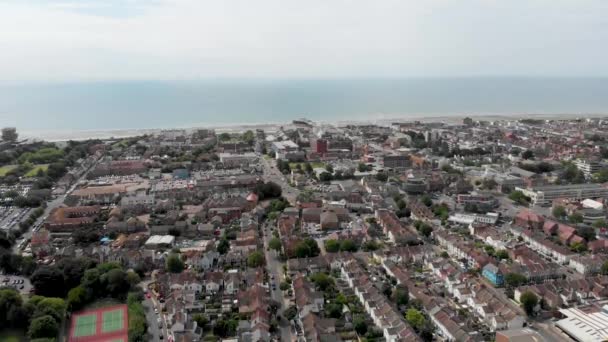 Nagrania lotnicze z miasta Worthing, dużego nadmorskiego miasta w Anglii i dzielnicy o statusie gminnym w West Sussex, Anglia, pokazujące typowe osiedla mieszkaniowe i przedsiębiorstwa w jasny słoneczny dzień - Materiał filmowy, wideo